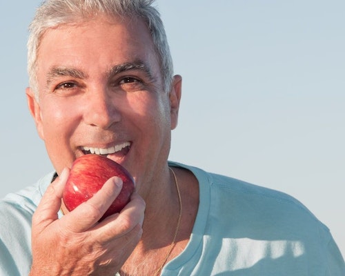 Older man biting into apple